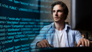 Homme qui écrit sur un clavier, en fond des lignes de code.