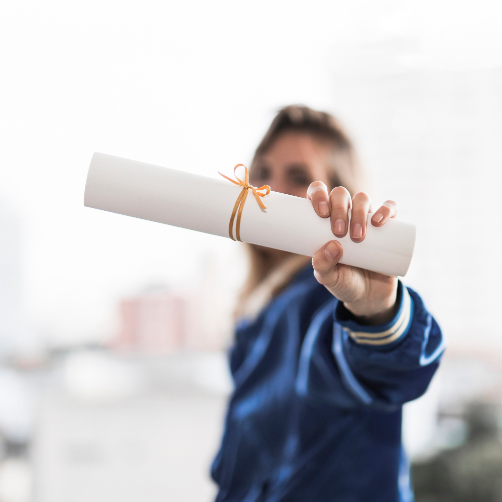 Une personne tenant un diplôme dans la main.