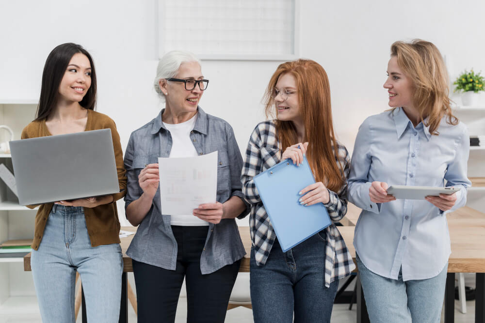 4 femmes dans un environnement professionnel avec des âges différents souriantes